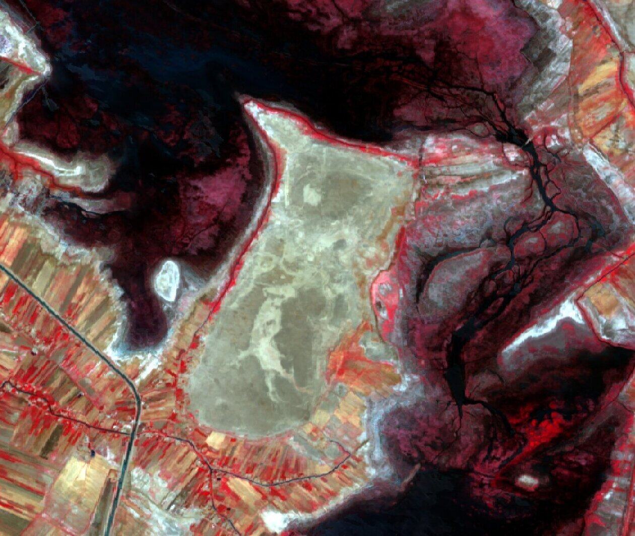 Satellite image of a landscape with varying colours of red, brown and grey.