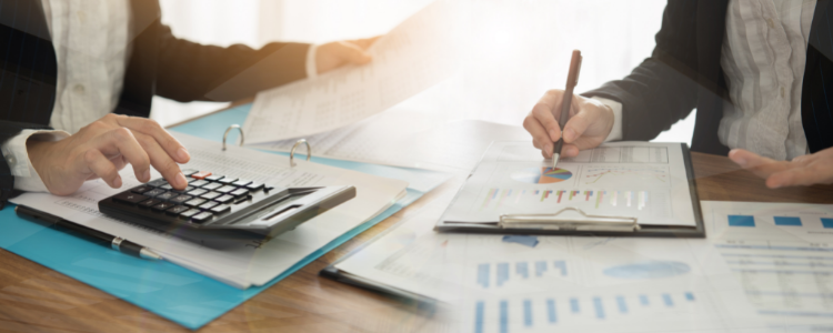 Two business people around a table with accounting papers