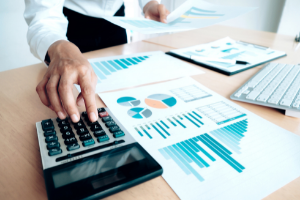 Businessman using a calculator and graph