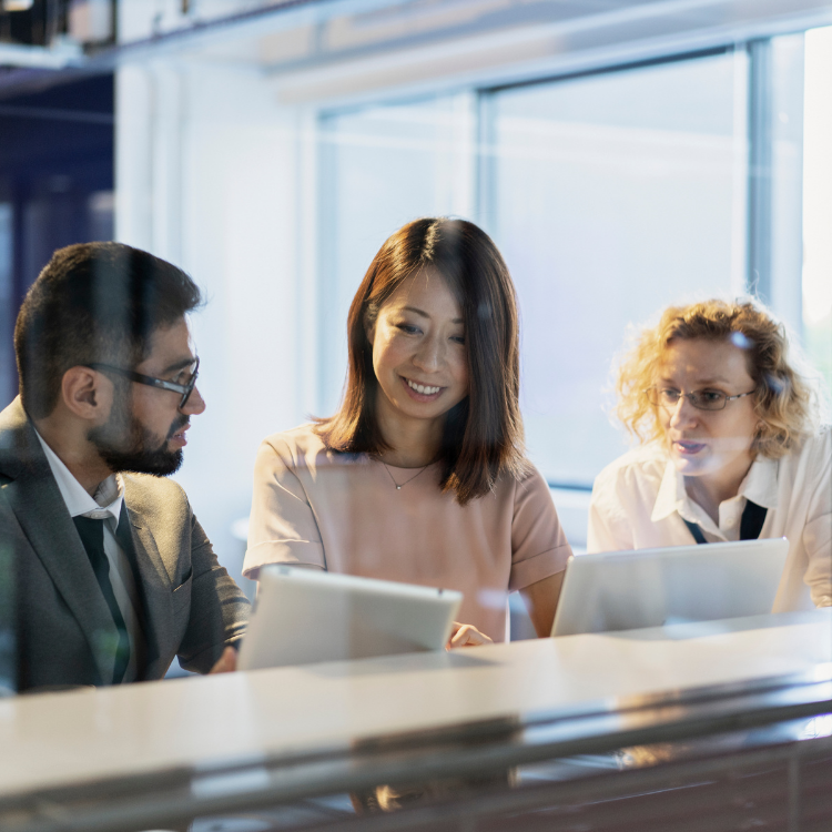 Three business people looking at a laptop