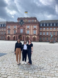 Three students stood in front of a building
