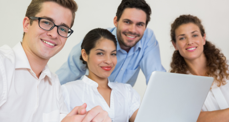 Business People sat around a table with a laptop