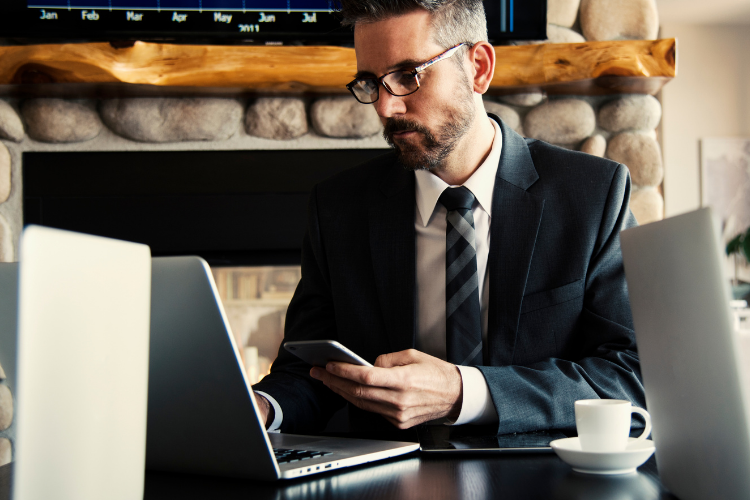 Business man looking at a laptop and phone