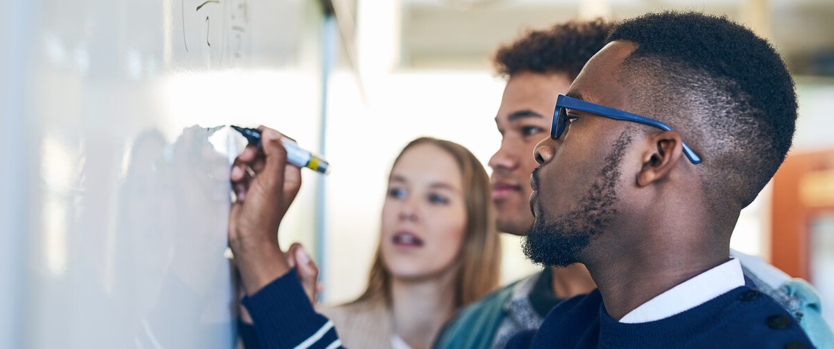 Students writing on a whiteboard