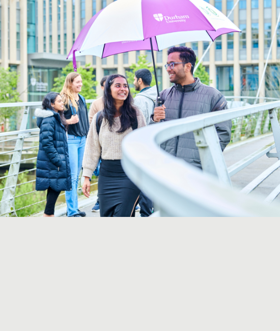 DUBS students cross the bridge outside the business school carrying an umbrella