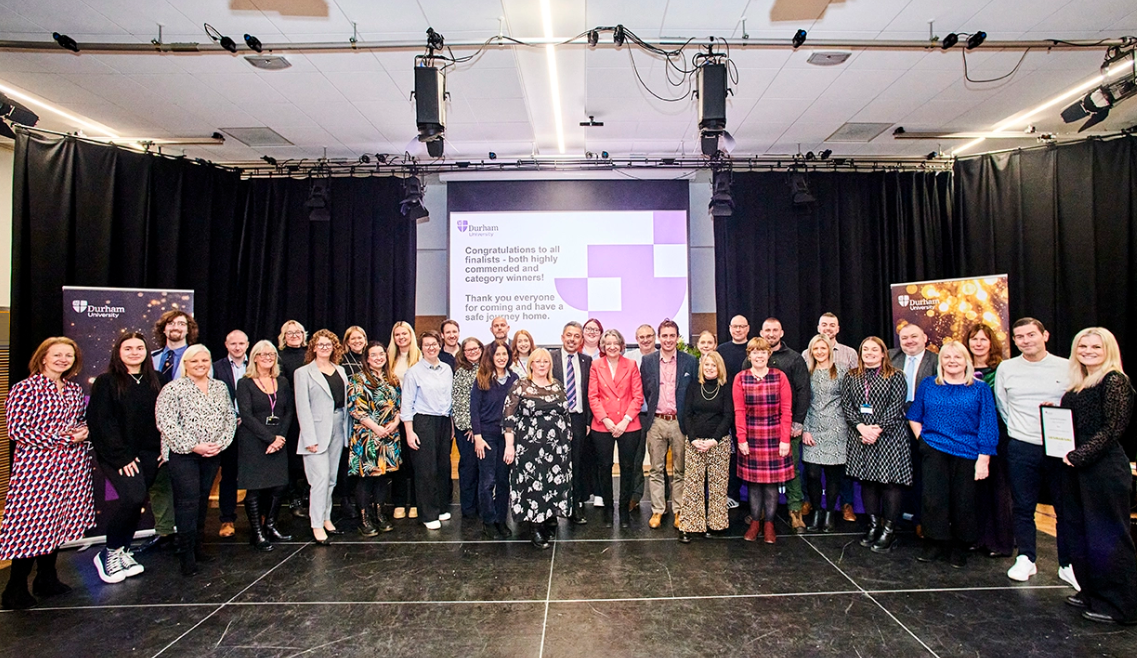 A photo of the winners of the professioanl services awards standing in front of a powerpoint screen detailling the award celebration