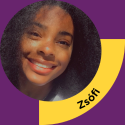 Young woman with curly dark hair smiling at the camera