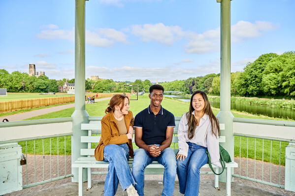 Three students sitting on a bandstand