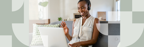 Woman sat on sofa with headset waving at laptop