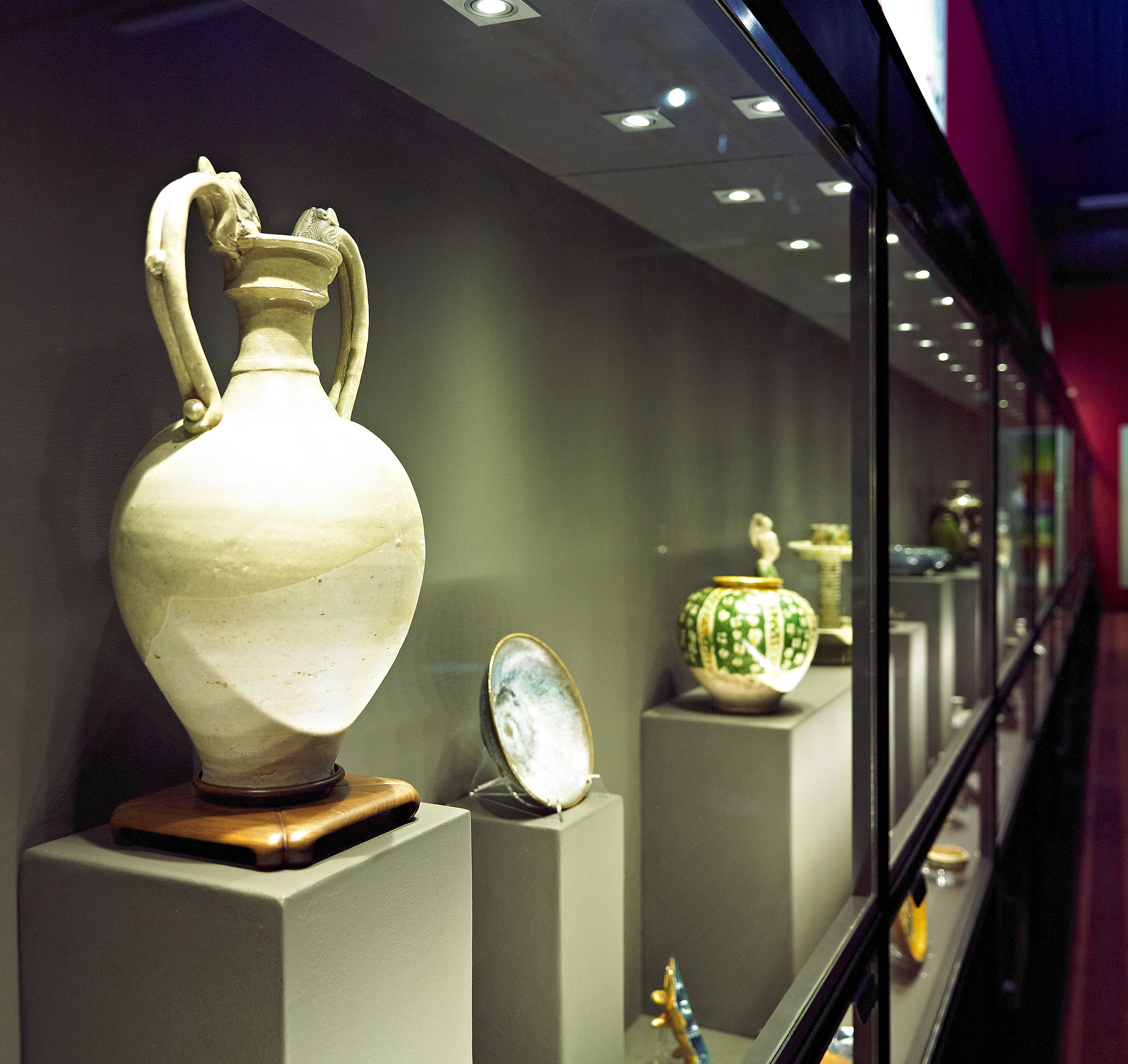 Various items of pottery on display in a glass cabinet