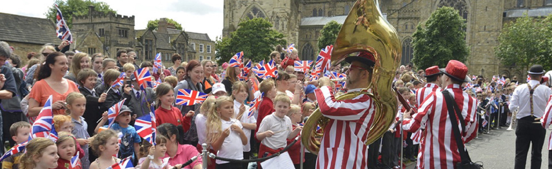 Crowds of people waving Union Jack flags on Palace Green for the Queen's Diamond Jubilee in 2012