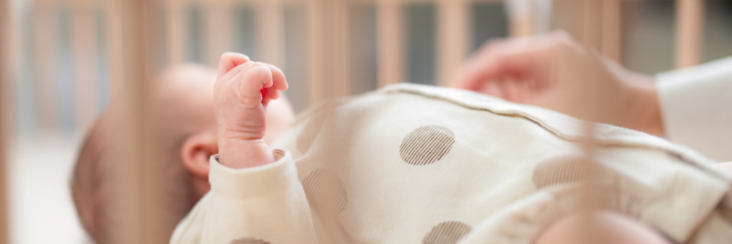 Newborn baby lying in a cot