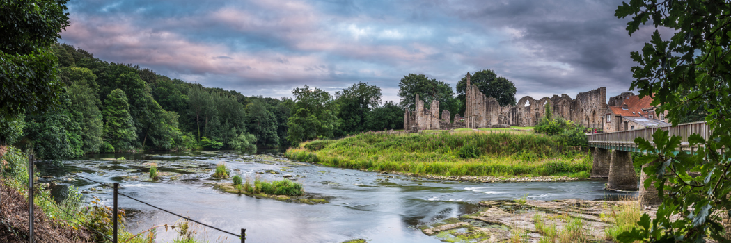 River Wear in the foreground flowing past the remains of Finchale Priory in County Durham