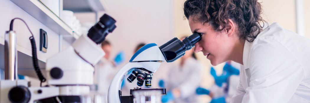 A scientist looking into a microscope