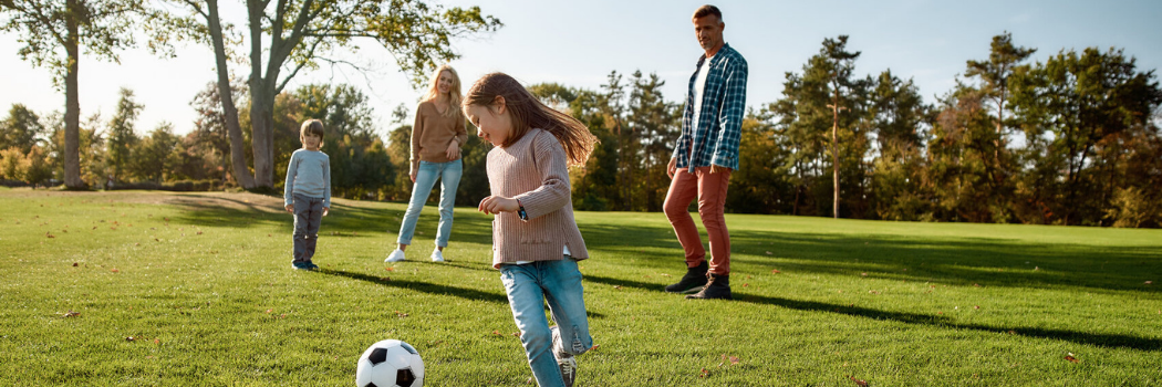 Family exercising playing football.