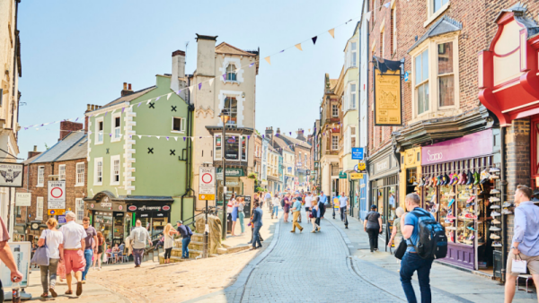 A street in Durham, with old buildings and people walking down the street