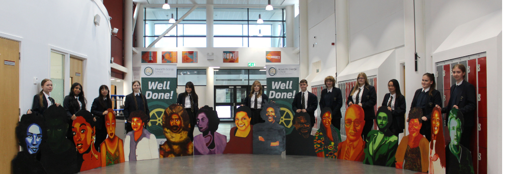A group of school pupils with large pieces of artwork.