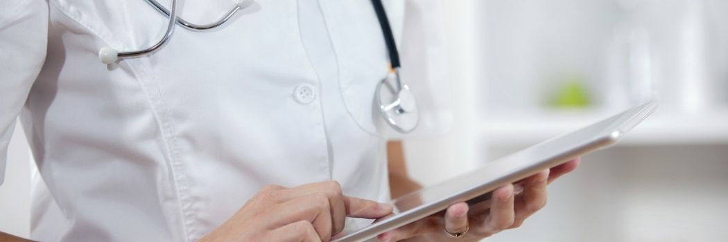 A doctor check their records on a tablet device