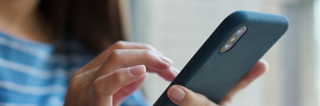 Close up of a woman's hand operating a mobile phone