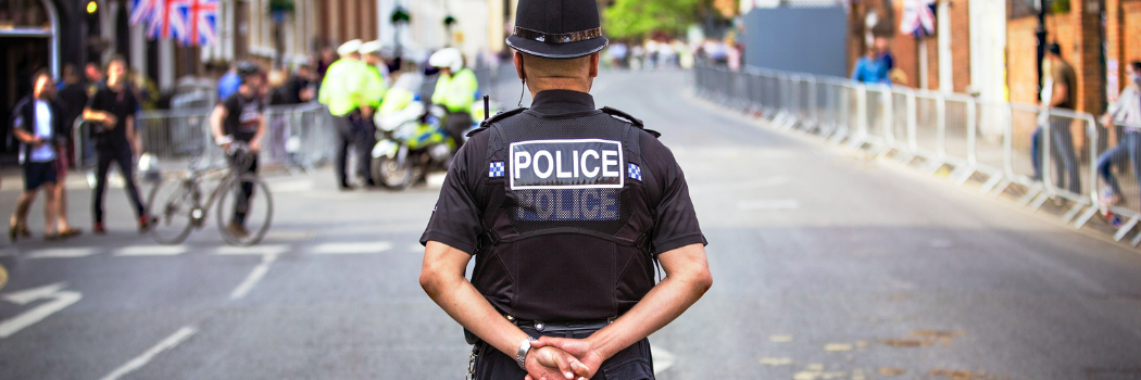 TMale police officer standing in quiet street