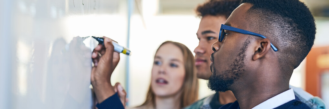 Academics working together on a whiteboard