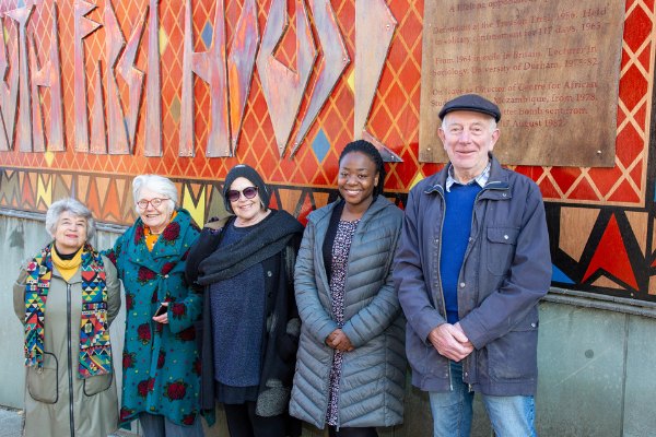 People standing in front of Ruth First House mural