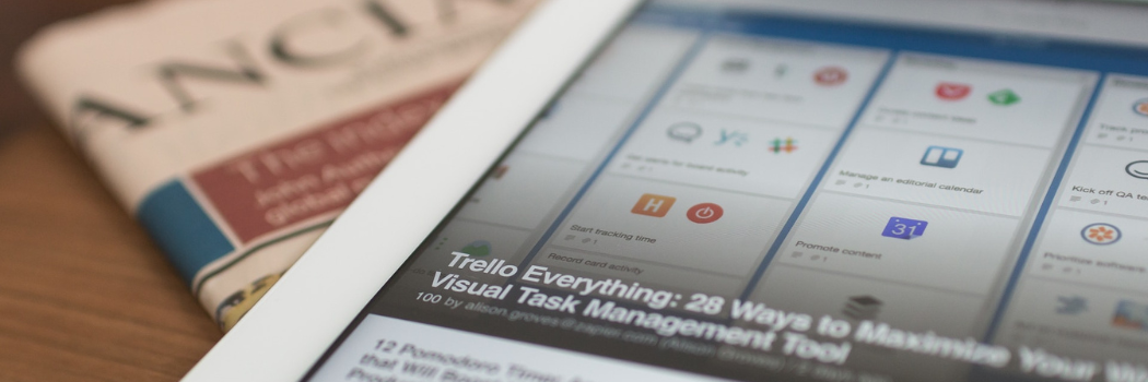 A close up of a computer tablet on top of a newspaper