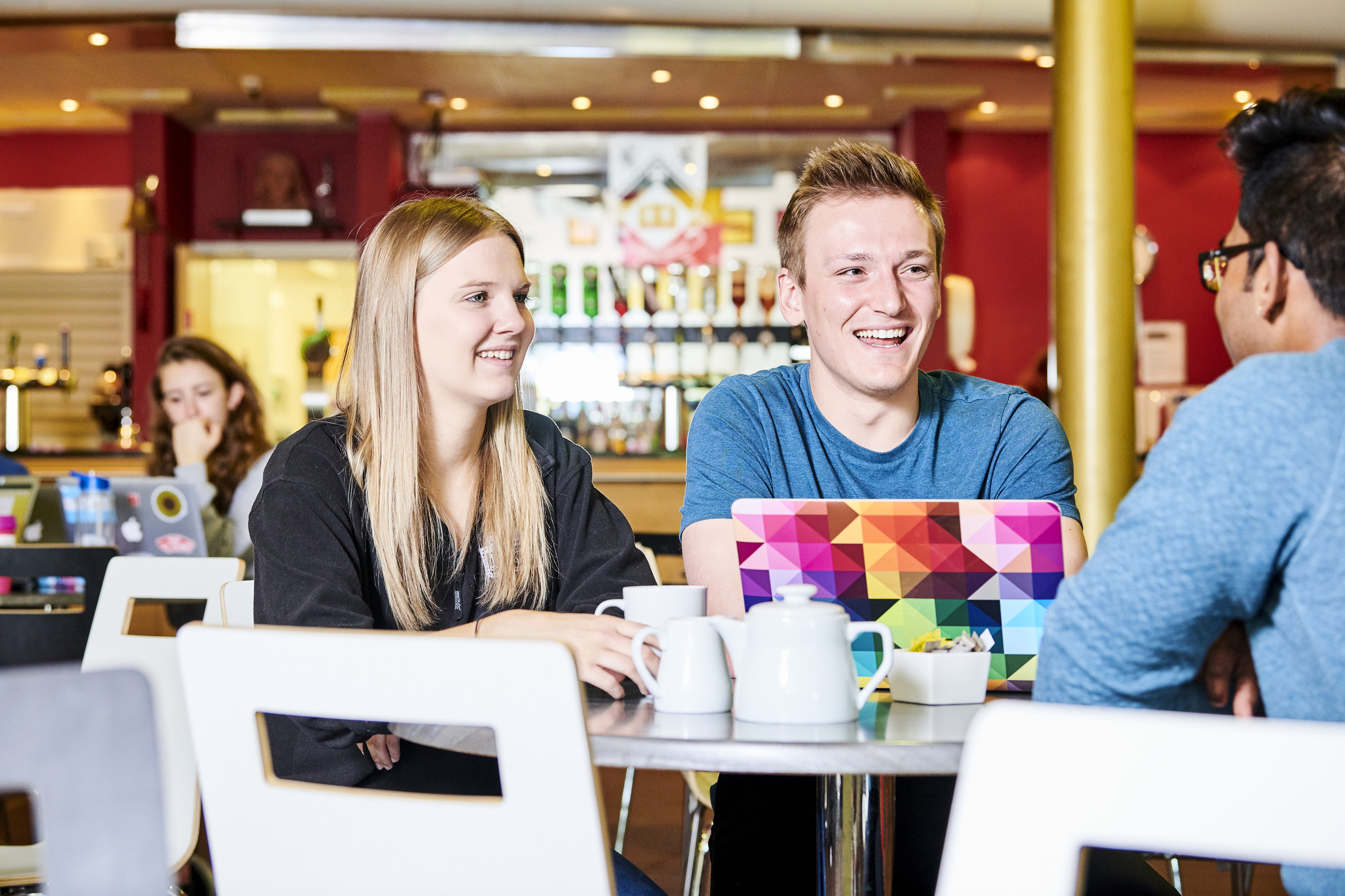 Students sitting round a table in the College bar
