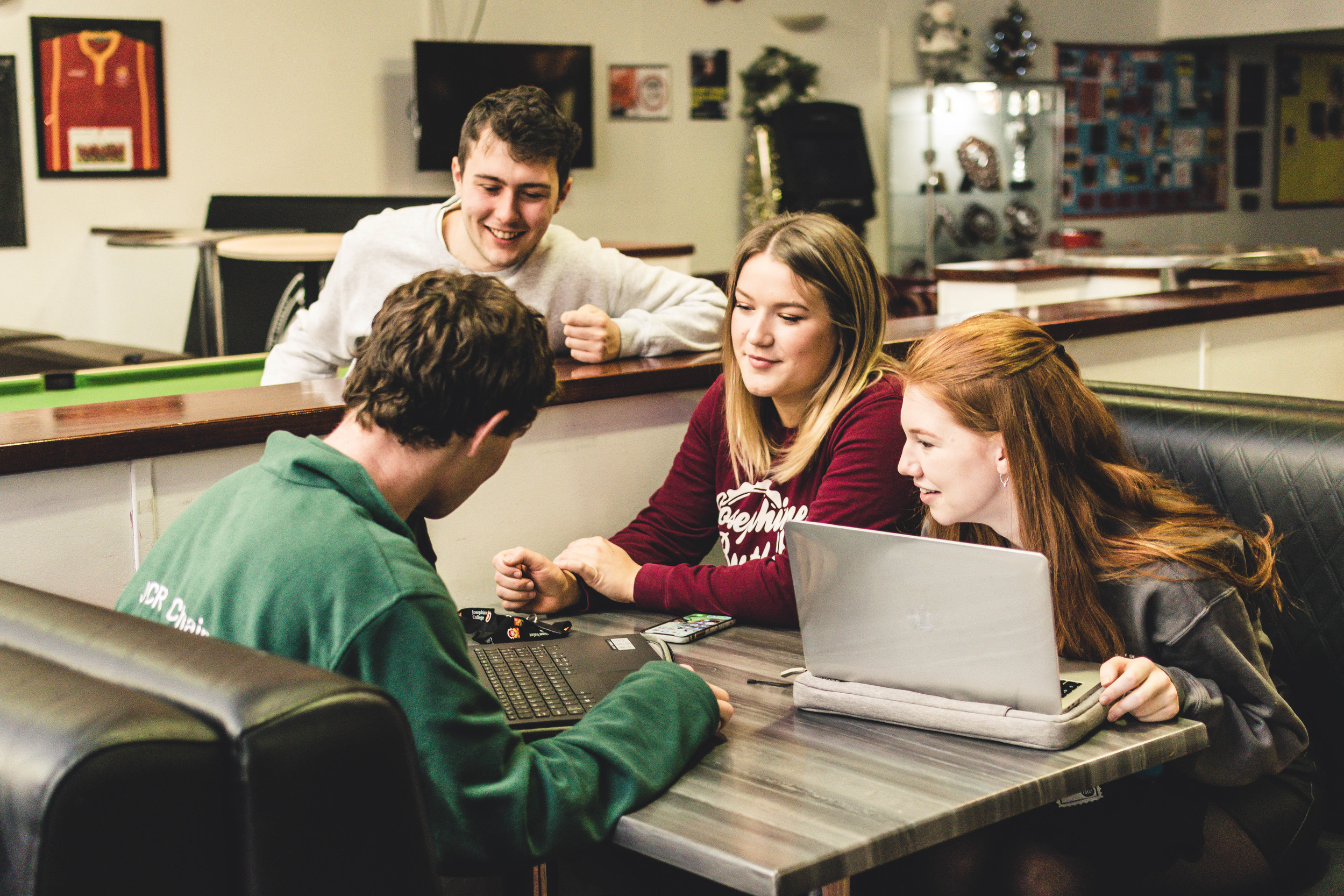 Students working in a group on laptops in the common room