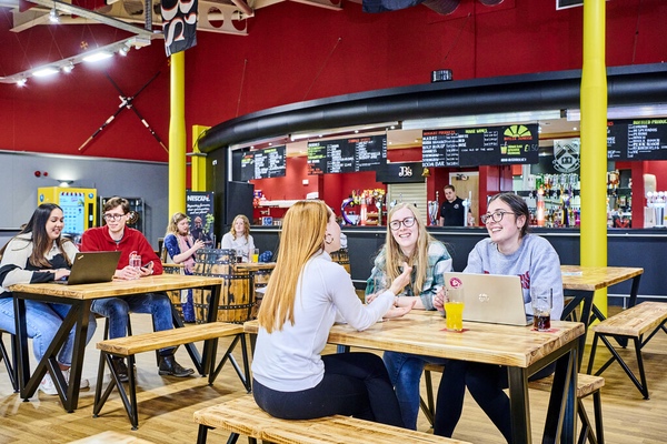 A group of students sitting at tables talking