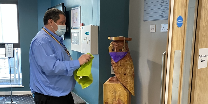 A picture of Lee Worden oiling a wooden owl