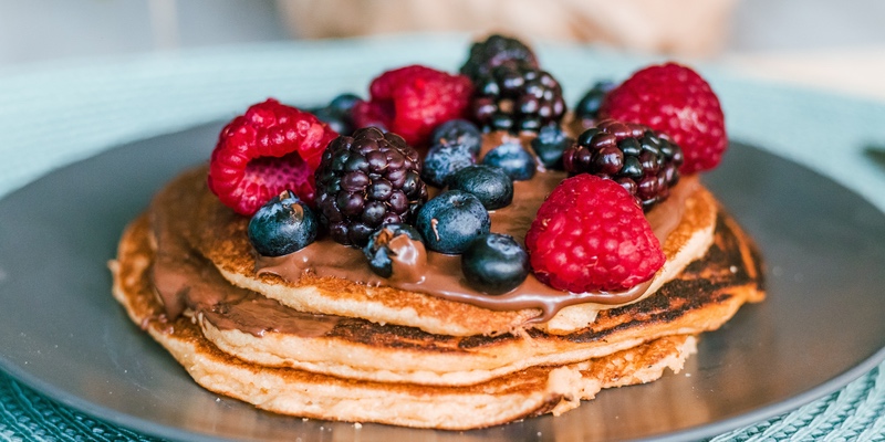 A picture of 3 pancakes with berries