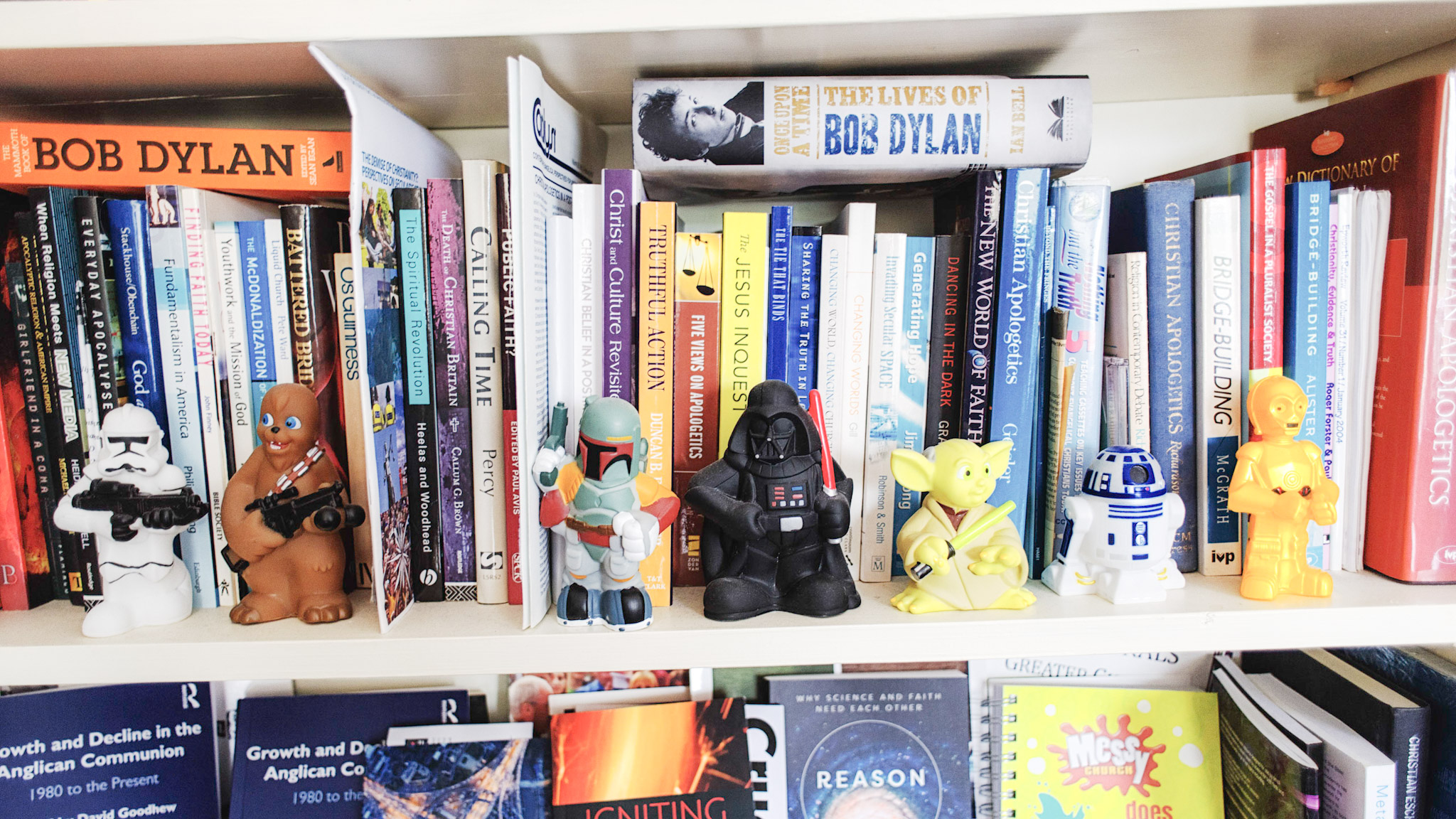A shelf covered in books and figurines