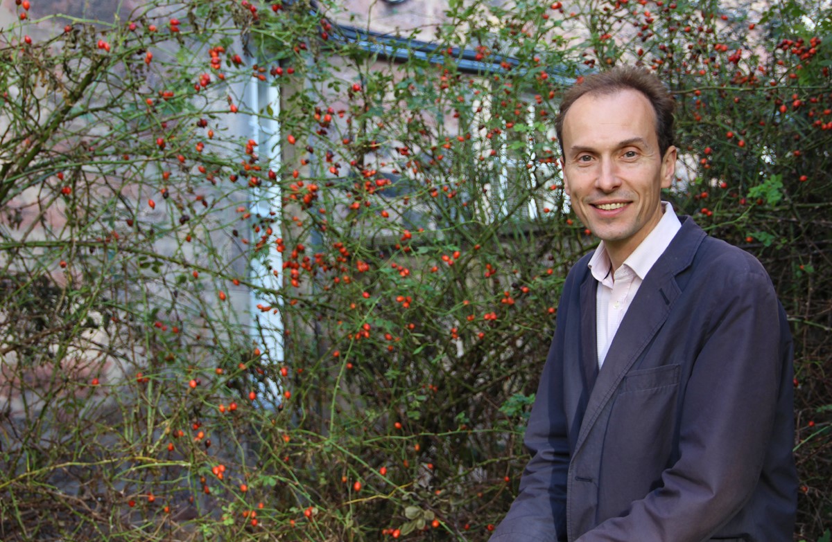 portrait of Jolyon Mitchell next to a bush