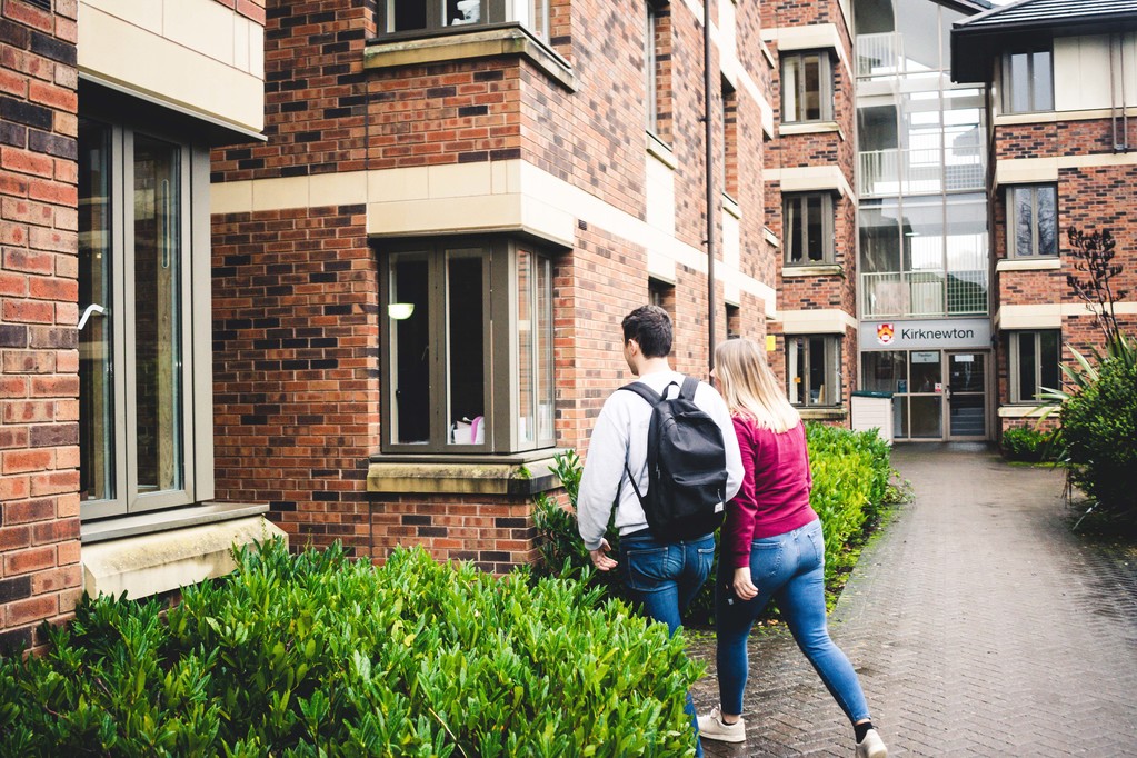 Two students entering a college building