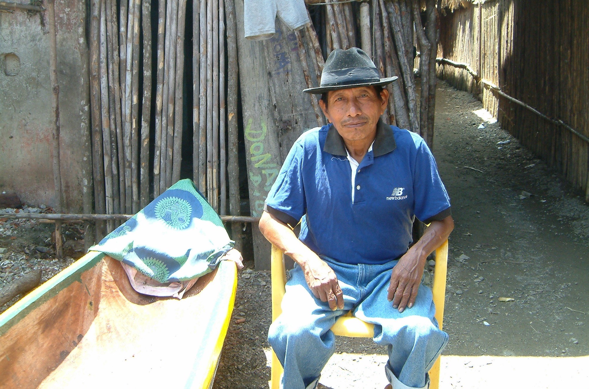 Man sitting in a chair outside a wooden shack in Panama