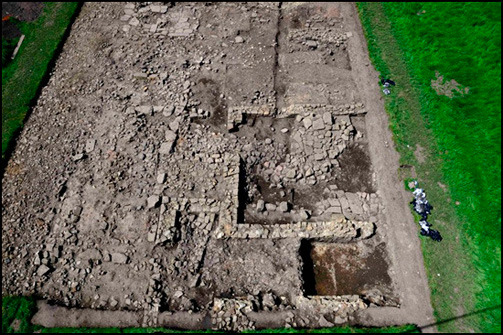 Aerial view of stone buildings and road within the vicus