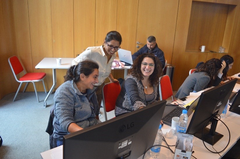 Training Manager helping workshop participants sat in front of computers