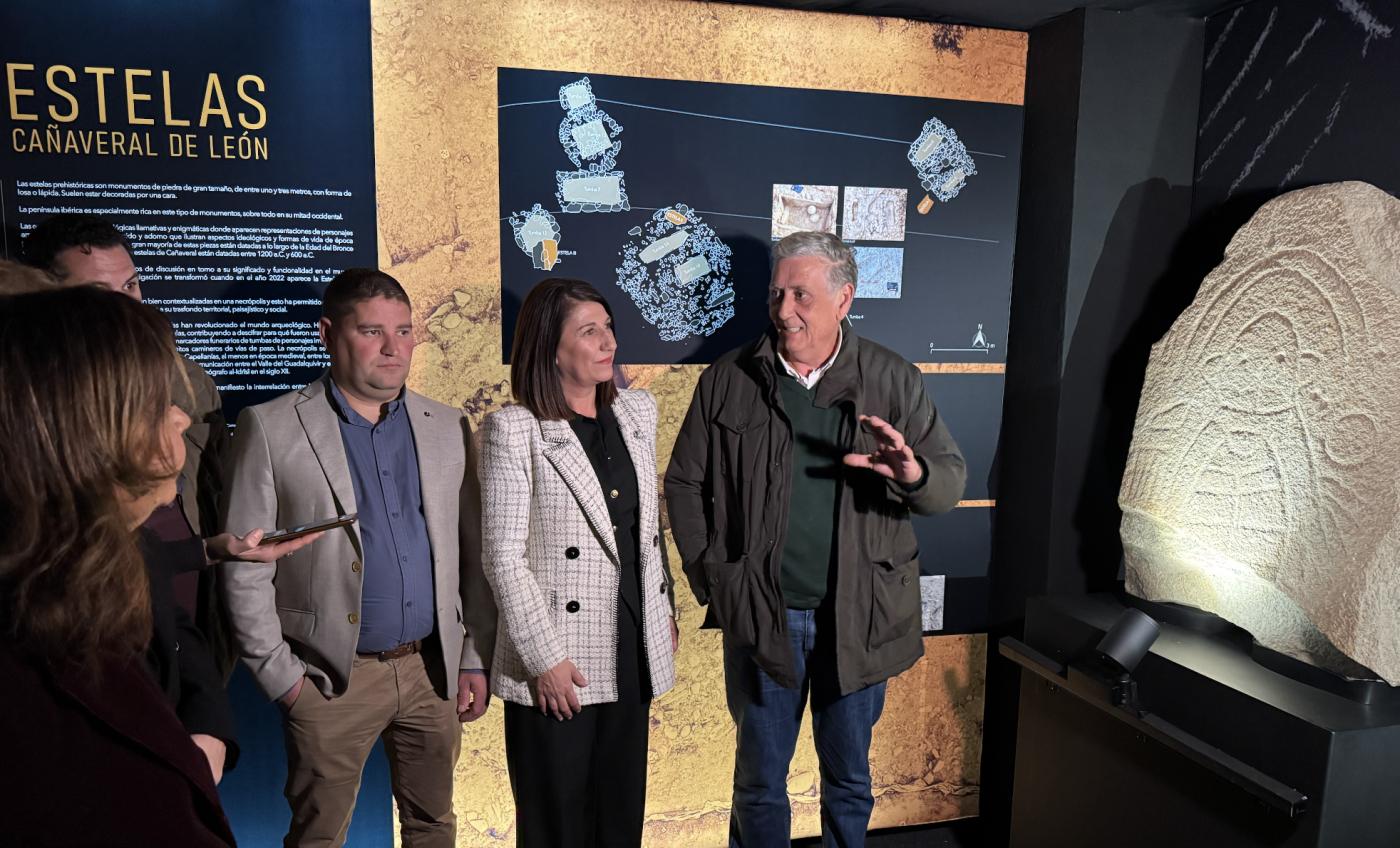 People gathered at the inauguration of a space dedicated to the stelae discovered at Cañaveral de León. A decorated stela is displayed on the right hand side of the photo.