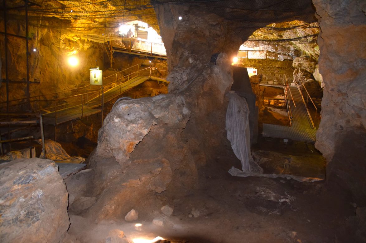 Inside a cave lit with artificial light and with a man-made walkway