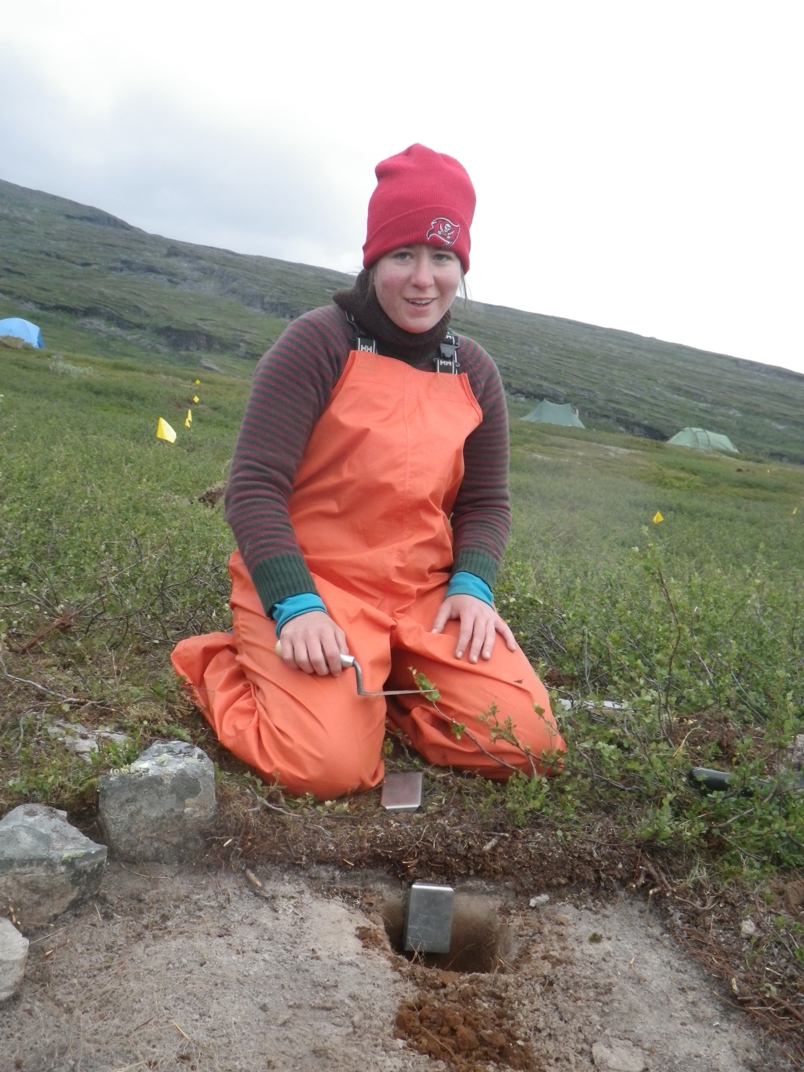 Staff member doing a soil sample in a field