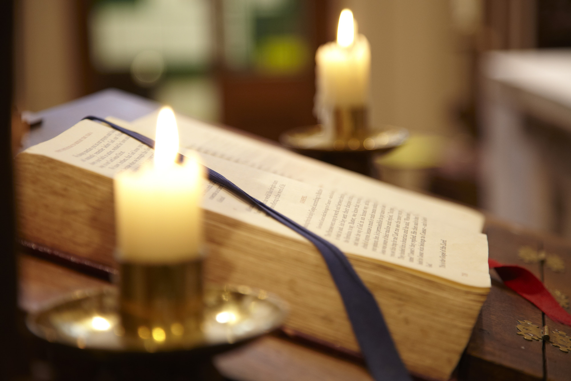 Close-up of church candle with book behind