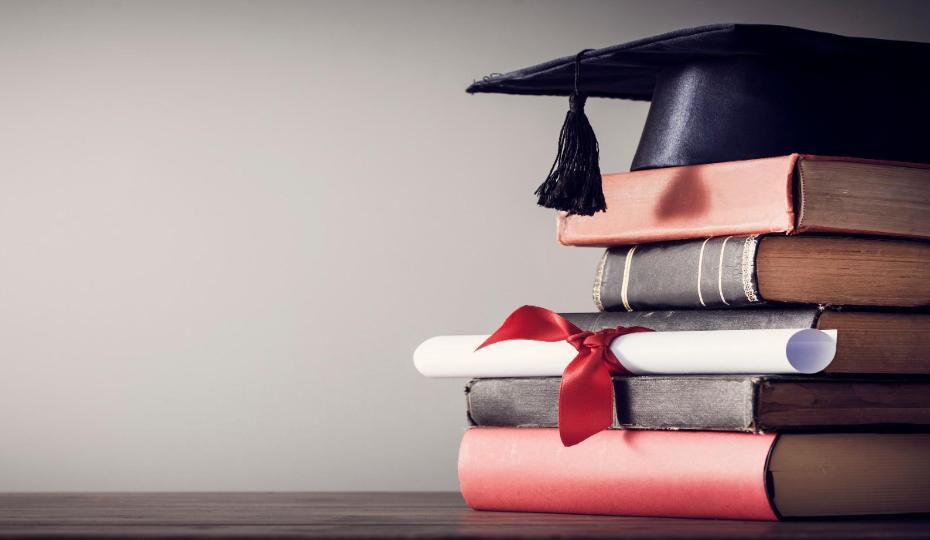 Old books with graduation cap on top