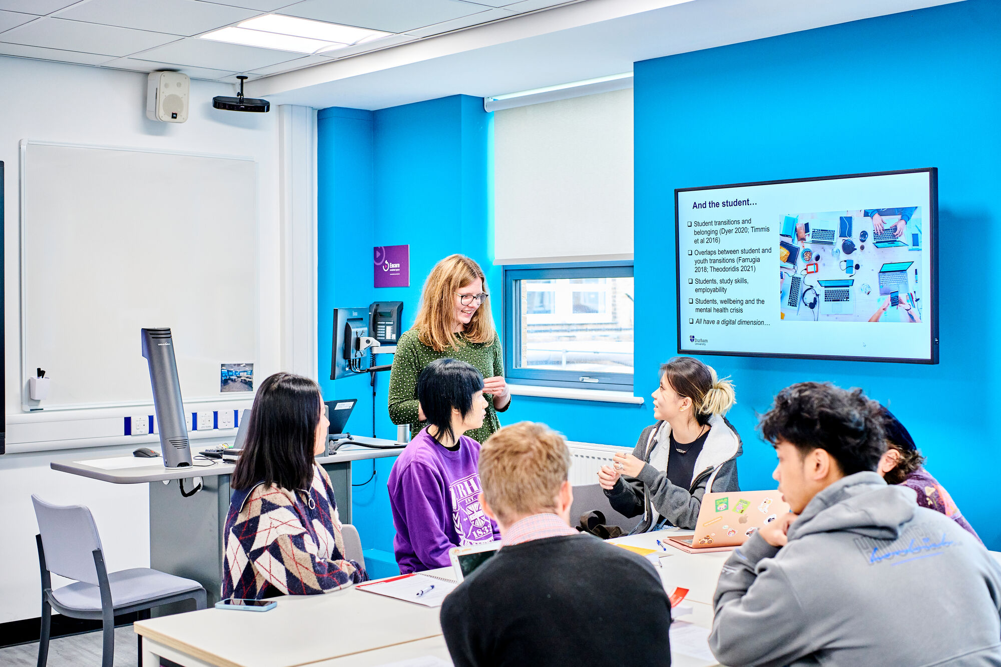 A female academic in discussion with students