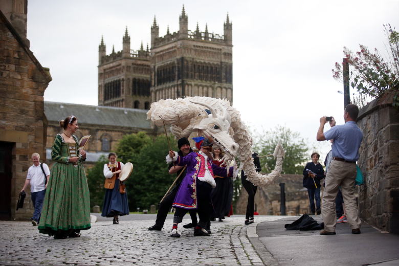 A large white dragon puppet in front of Durham cathedral