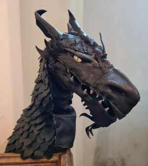 Head of a black dragon puppet with fierce yellow eyes
