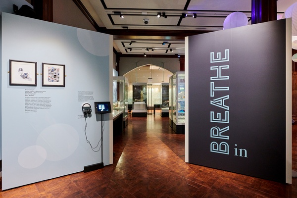 The Breathe In exhibition space entrance lined with posters