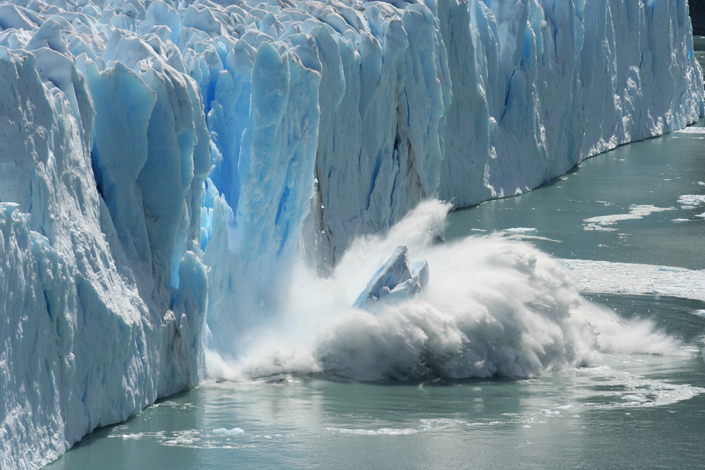 A large piece of ice drops into the sea as it melts