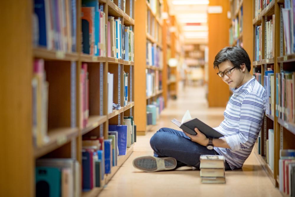 TMan reading book in library