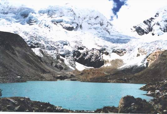 A lake with towering mountains and a glacier